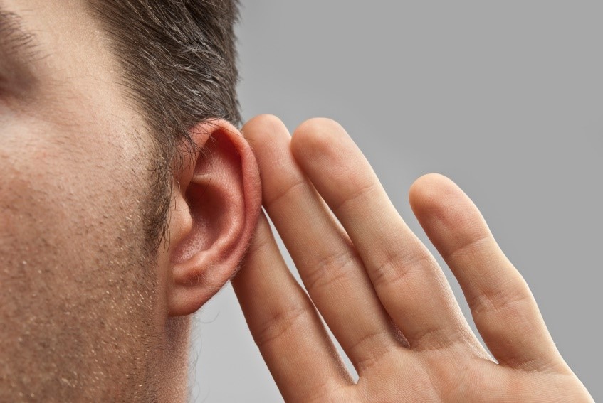 Man with hearing loss holding a hand to his ear